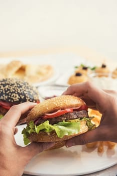 Man eating burgers at table, pov view