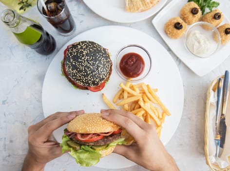 Man eating burgers at table, pov view