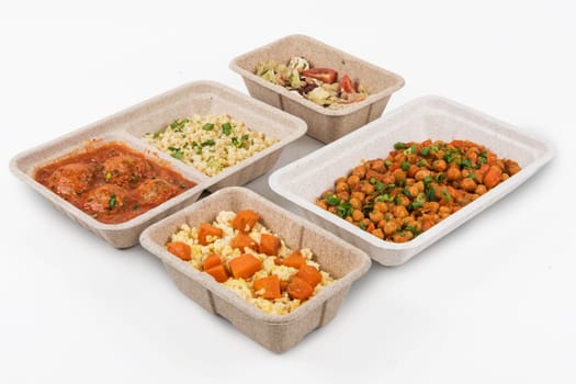 Healthy food delivery for fitness nutrition or diet. Daily meals in paper boxes on a white background