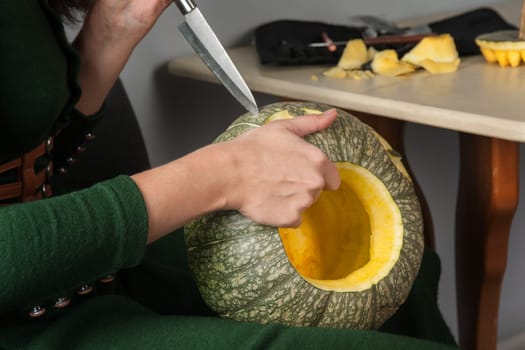 woman hands making pumpkin for halloween holidays.