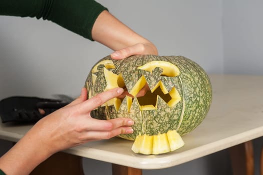 woman hands making pumpkin for halloween holidays.