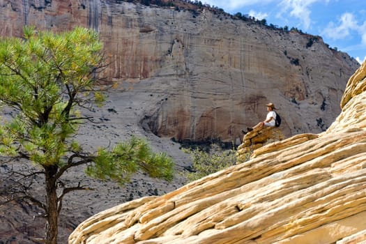 ZION NATIONAL PARK, UT - SEPTEMBER 14: Man sits on a rock on Angels Landing in Zion National Park in Utah on September 14, 2015