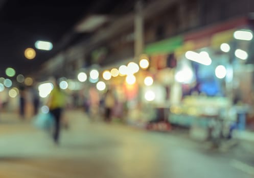 Blurred image of tourists walking at night market