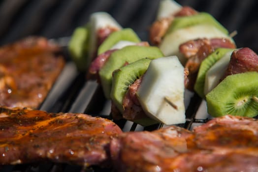 close on raw meat with fruits on the grill