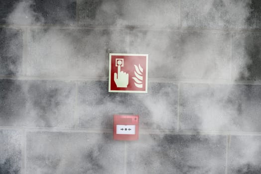 emergency fire exit on the stone wall with fire smoke