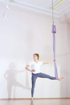 a woman is practicing yoga on a hose,aerial yoga