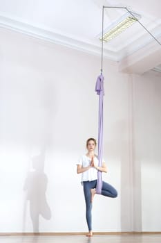 a woman is practicing yoga on a hose,aerial yoga