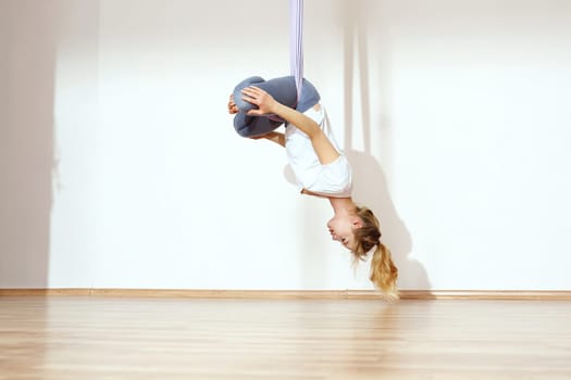 a woman is practicing yoga on a hose,aerial yoga meditation. woman meditating in the position of an inverted lotus flower