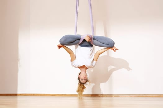a woman is practicing yoga on a hose,aerial yoga meditation. woman meditating in the position of an inverted lotus flower