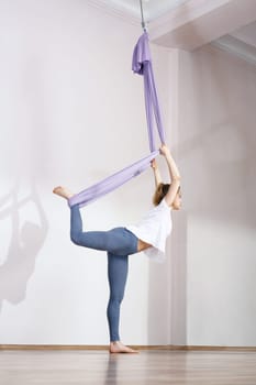 a woman is practicing yoga on a hose,aerial yoga