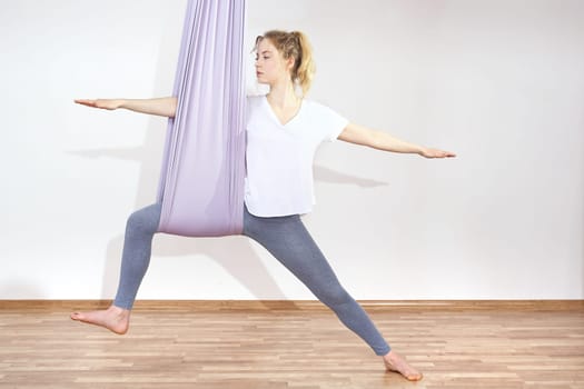 a woman is practicing yoga on a hose,aerial yoga