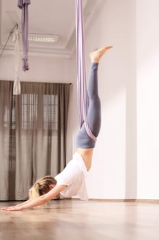 a woman is practicing yoga on a hose,aerial yoga