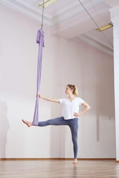 a woman is practicing yoga on a hose,aerial yoga