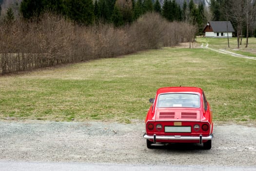 beautiful red retro sport car in the spring nature