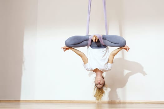 a woman is practicing yoga on a hose,aerial yoga meditation. woman meditating in the position of an inverted lotus flower