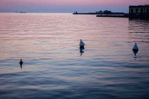 beautiful sunset in Trieste harbor floats in the water
