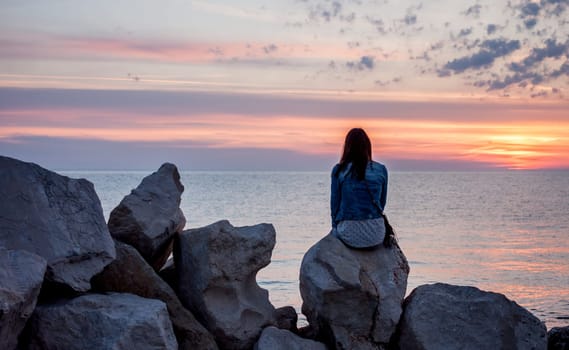 colorful beautiful sunset over Adriatic sea woman looking at horizon