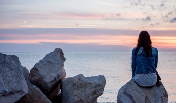 colorful beautiful sunset over Adriatic sea woman looking at horizon