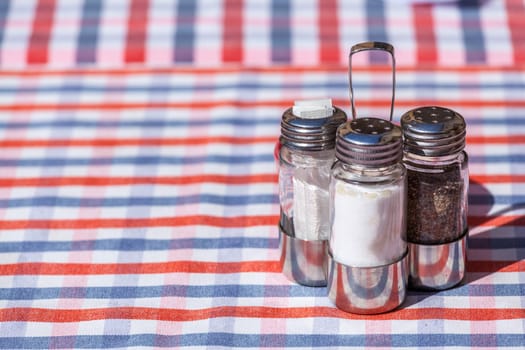 Salt, pepper and toothpick set over an outdoor restaurant table in Italy