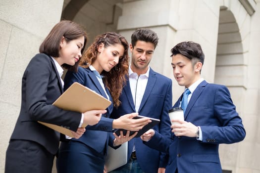 Group of business people discuss on tablet