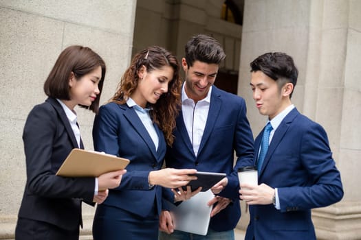 Group of business people discuss on digital tablet