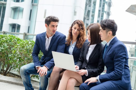 Business people sitting down outdoor and working otgether