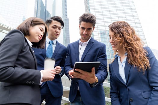 Business partners discuss something on tablet computer
