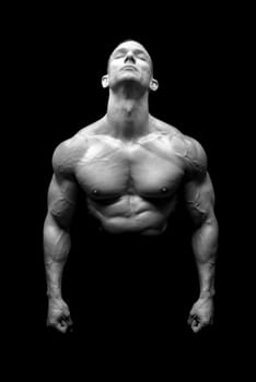 Power athletic man with great physique. Strong bodybuilder showing perfect body isolated in black.