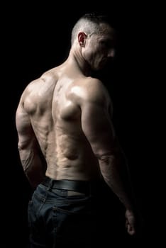 Power athletic man with great physique. Strong bodybuilder showing his shoulders and back