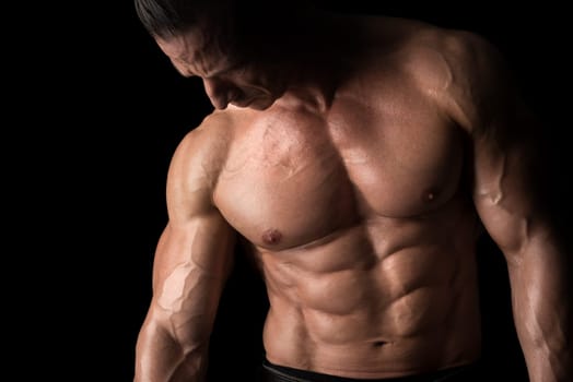 Power athletic man with great physique. Strong bodybuilder with six pack, perfect abs, shoulders, biceps, triceps and chest.