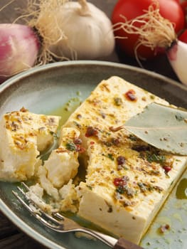 Organic feta cheese with herbs and olive oil on a rustic plate, healthy food