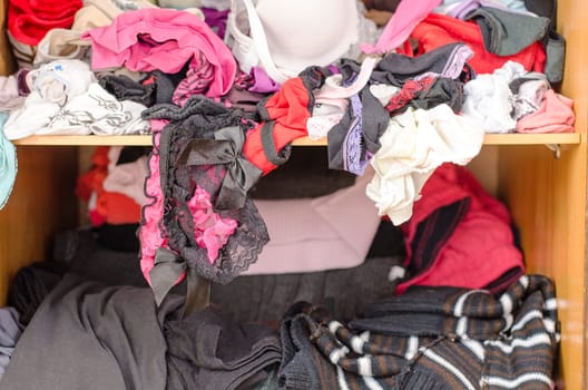 Pile of carelessly scattered clothes in wardrobe
