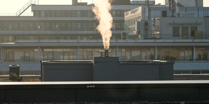 Smoke from a fireplace in the industrial area with backlight