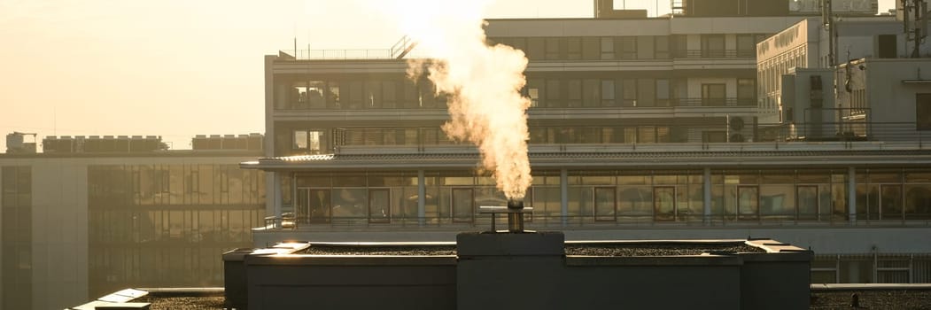 Smoke from a chimney in the industrial area with buildings