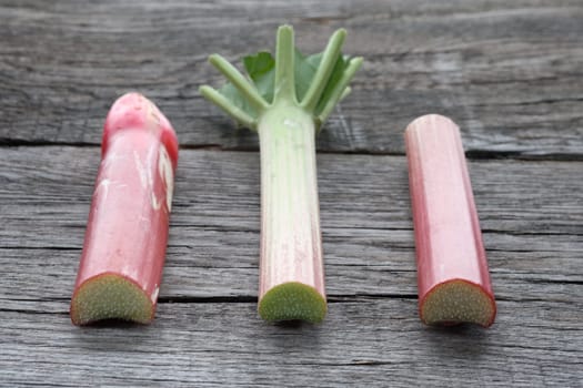 Pieces of raw rhubarb on wood