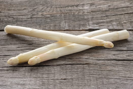 White asparagus raw on rustic wood