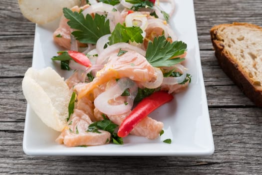 Plate of ceviche of salmon,onions,chili and parsley