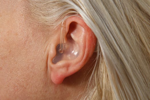 modern digital hearing aid in woman's ear
