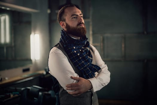 Handsome bearded man hipster with stylish beard in white shirt and chekered scarf standing with serious face in beauty salon or barbershop