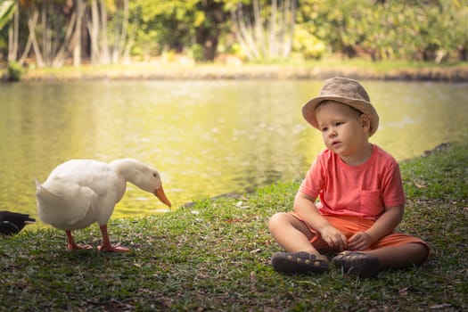 Boy and duck near lake. Mauritius