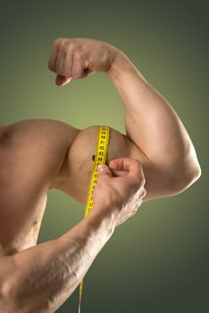 Man's strong arm with measuring tape isolated