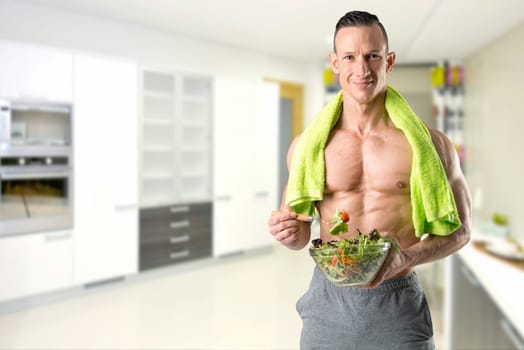 Powerful athletic man with great phisique eating a healthy salad.
