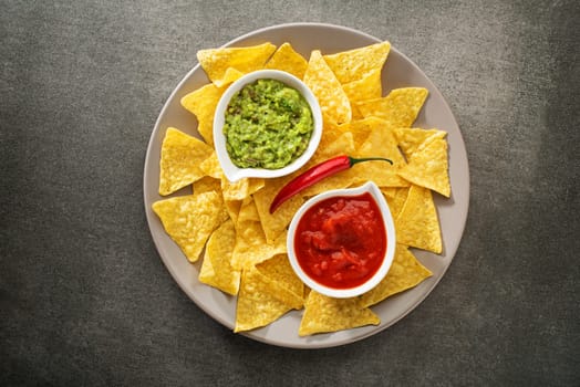 Guacamole and tomato salsa with corn nachos chips