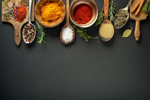 Fresh herbs and spices on a black background
