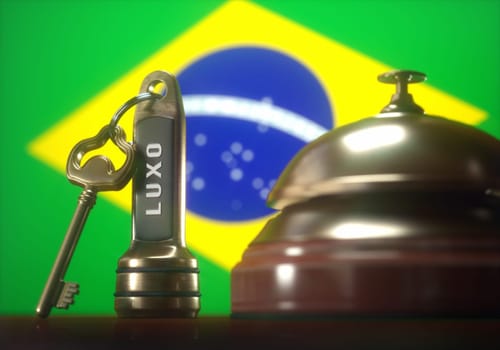 Luxury hotel key and vintage golden bell of the Brazil on the wooden table of the lobby service.
