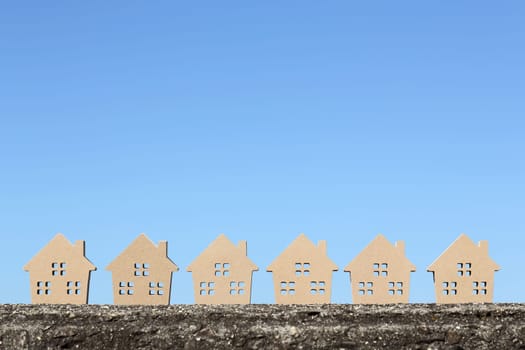 wooden toy house with tree against blue sky