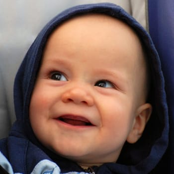 Smiling baby portrait about little baby boy in hood.