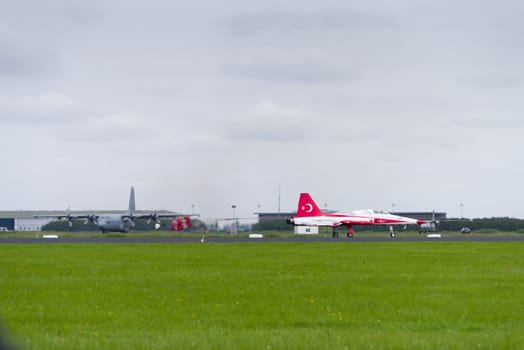 LEEUWARDEN, NETHERLANDS - JUNE 10, 2016: One of the NF-5 Canadair fighter planes of Turkish Star aerobatic demonstration team is landing with a parachute