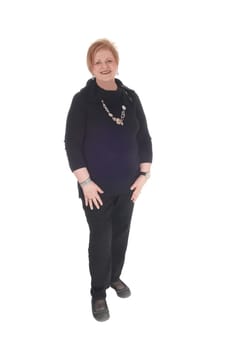 A older senior woman in a black dress and big necklace standing smiling.isolated for white background..