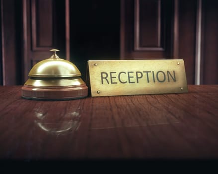 Vintage bell with "reception"" message on the wooden desk of the lobby service."